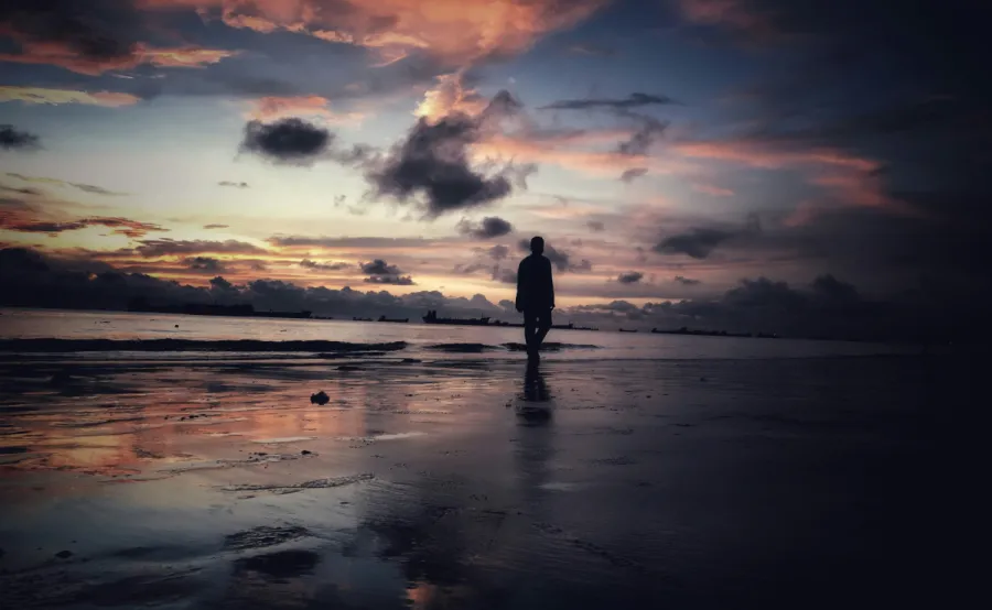 Image of solitary man on a dark beach
